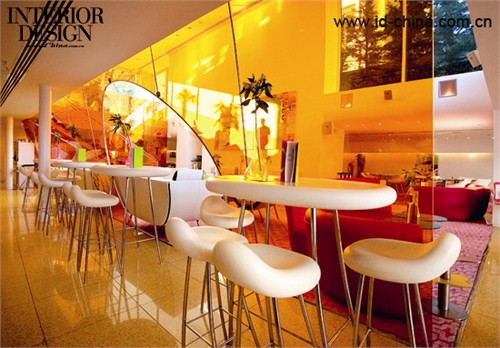 橙色玻璃濾去了刺目的陽光，給白色的家具也染上了淡淡的暖黃色。